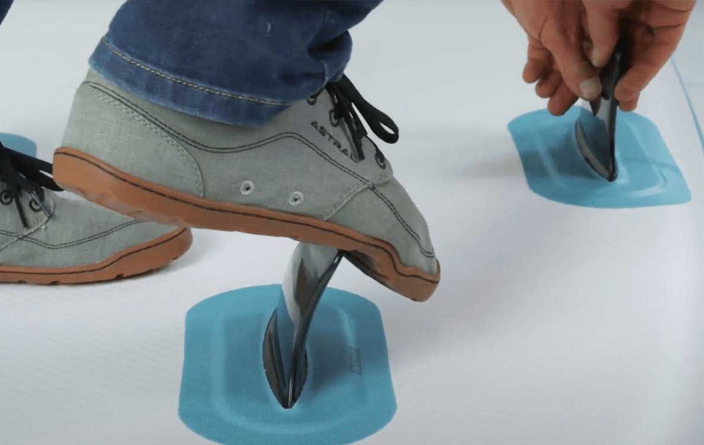 Close-up of a paddler installing a removable fin on a TAHE SUP board.