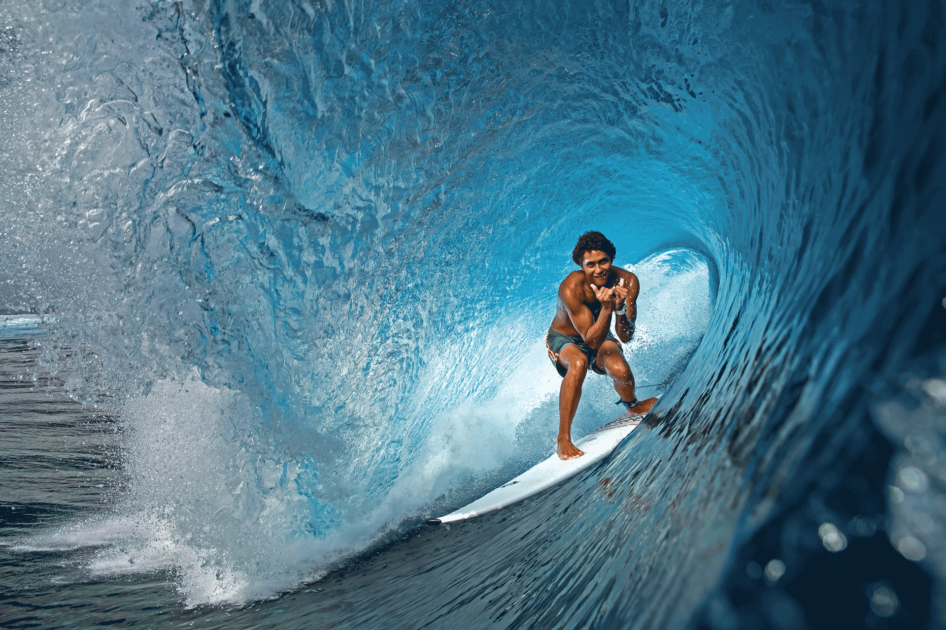 Surfer getting barreled in a turquoise hollow wave on a white Bic Sport board